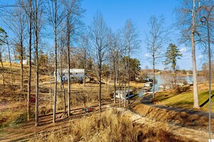 A rural landscape with a lake, houses, and a railway track.