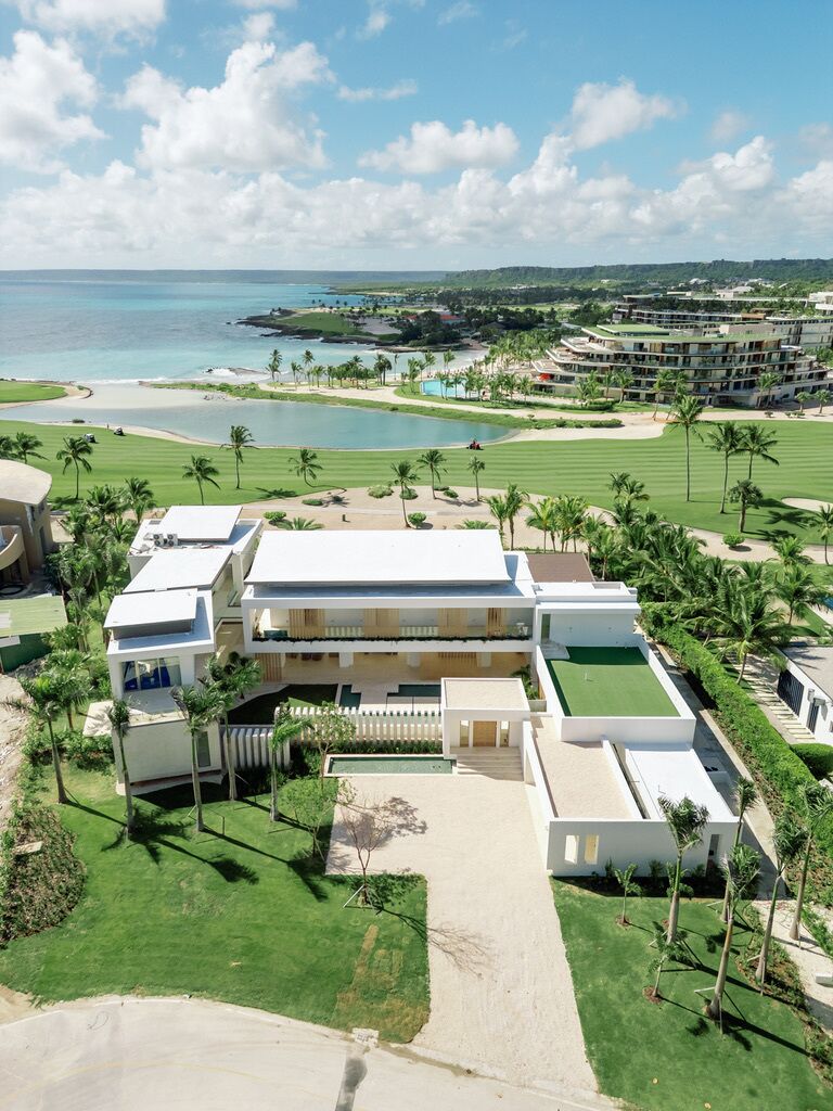 A modern resort with a pool, multiple guest rooms, and a view of the ocean.