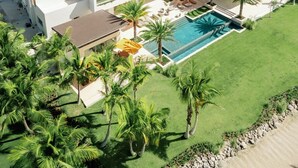 A modern resort with a pool, beachfront view, and multiple buildings. - Shemesh Residence - Ocean Golf Views With Full Staff at Unique Cap Cana Villa (Punta Cana)