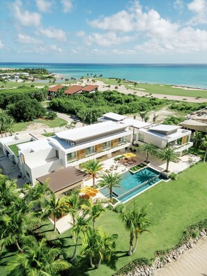 A modern resort with a pool, beachfront view, and multiple buildings. - Shemesh Residence - Ocean Golf Views With Full Staff at Unique Cap Cana Villa (Punta Cana)