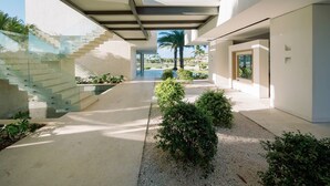 A modern architectural design with a central courtyard, glass staircases, and a view of the surrounding landscape. - Shemesh Residence - Ocean Golf Views With Full Staff at Unique Cap Cana Villa (Punta Cana)