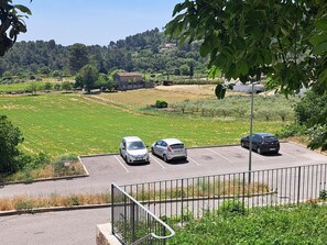 Ein Parkplatz mit drei Autos, einem Rasen und einem Gebäude im Hintergrund.