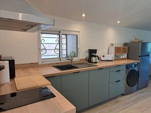 Eine moderne Küche mit eingebautem Geschirrspüler, einer Kaffeemaschine und einem Kühlschrank.