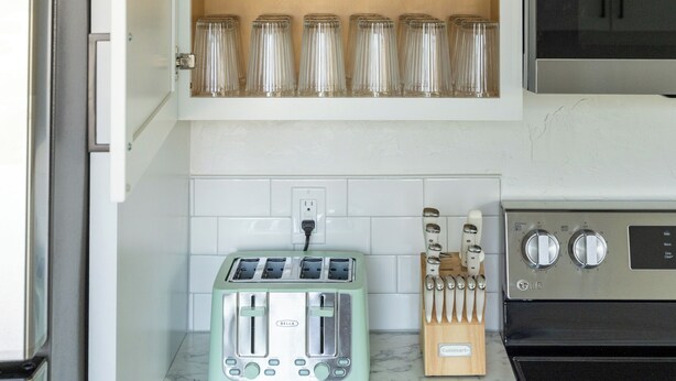 A kitchen with a built-in spice rack, a toaster, and a microwave. - Game Day Getaway - 4BR/3BA, Sleeps 10, Walk to WSU (Pullman)
