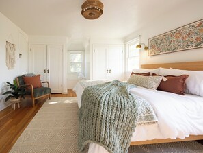 A bedroom with a bed, a chair, a plant, and a window. - Game Day Getaway - 4BR/3BA, Sleeps 10, Walk to WSU (Pullman)