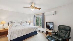 A bedroom with a bed, a ceiling fan, a TV, a chair, and a window with curtains. - Sagamore by Avantstay Heated Pool + Game Room Near Gore + Main St (North Creek)