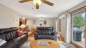 A living room with a sofa, two chairs, a coffee table, a ceiling fan, and a dining area with a table and chairs. - Sagamore by Avantstay Heated Pool + Game Room Near Gore + Main St (North Creek)