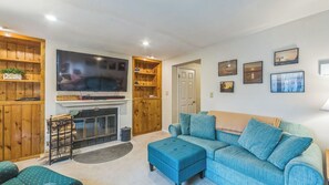 Ein Wohnzimmer mit Kamin, Fernseher und einer Couch.