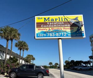 Schild für The Marlin Vacation Condominiums mit wöchentlichen und monatlichen Ferienwohnungen.