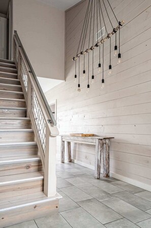 Eine Treppe mit Holzwand, einer rustikalen Bank und einer Wandleuchte.