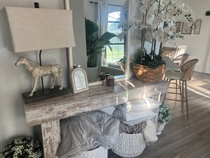 A room with a fireplace, a horse sculpture, a mirror, and a dining area with chairs. - 3 min to WEC, 10 min to HITS, beautiful 4 bedroom home w pool in Golden Hills (Ocala)