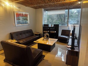 Ein modernes Wohnzimmer mit einer Ledersofa, einem Couchtisch und einer TV-Kommode.