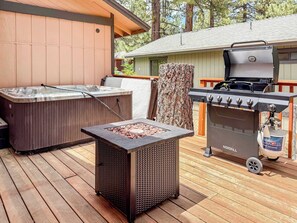 A hot tub, a grill, and a small table on an outdoor deck. - Bear Crest W/Spa Near Snow Summit (Big Bear Lake)