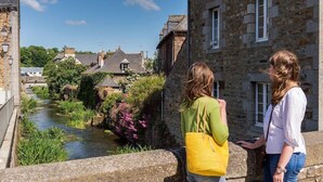 A stone building with a river in front, a bridge, and greenery. - Chez Mamig - GOUDELIN (GOUDELIN)