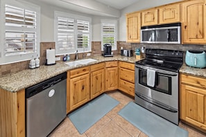 A kitchen with wooden cabinets, a stainless steel dishwasher, a built-in oven, and a microwave. - Lake Havasu Pool Retreat~3BR~Boat Parking~Sleeps 6 (Lake Havasu City)