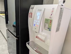 A digital water dispenser with a control panel, a QR code, and a warning label. - Johnson Bros Inn Taitung (Taitung)