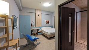 A bedroom with a bed, a desk, a chair, a wardrobe, and a door. - Johnson Bros Inn Taitung (Taitung)
