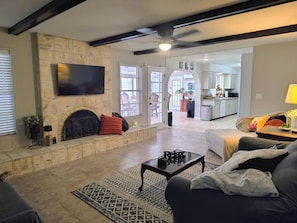 Una sala de estar con chimenea, televisor, sofá y una mesa de centro.