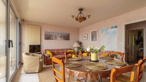 Zona pranzo con un tavolo rotondo, sedie e una ventola a soffitto.