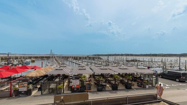 Una marina con barche, posti a sedere all'aperto e vista libera sul mare.