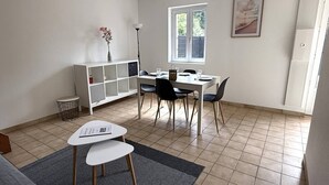 En matplats med ett vitt bord, svarta stolar, ett vitt skåp och ett fönster med utsikt.