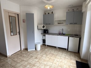 Eine kleine Küche mit Mikrowelle, Spüle und kleinem Kühlschrank.