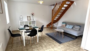 A modern living room with a dining area, a staircase, and a sofa with decorative pillows. - NEW LISTING, Domaine de KER-PAULT, between St Cast and Matignon, 2-bedroom apartment 5 minutes... (MATIGNON)