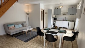 A compact living space with a dining area, kitchenette, and a staircase. - NEW LISTING, Domaine de KER-PAULT, between St Cast and Matignon, 2-bedroom apartment 5 minutes... (MATIGNON)