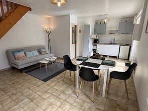 A compact living space with a dining area, kitchenette, and a staircase. - NEW LISTING, Domaine de KER-PAULT, between St Cast and Matignon, 2-bedroom apartment 5 minutes... (MATIGNON)