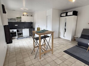 A compact living space with a kitchenette, a dining table, a sofa, and a wardrobe. - NEW, Domaine de KER-PAULT, between St Cast and Matignon, studio apartment 5 minutes from the beaches (MATIGNON)