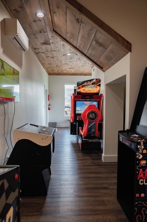 Ein schmales Entree mit Holzbalkendecke, Billardtisch und Spielautomaten.