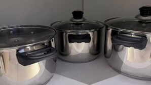 Keittiössä on työtasolla kolme ruostumatonta teräskattilaa.