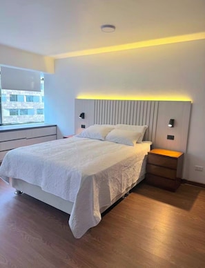 A modern bedroom with a bed, bedside tables, and a window. - Modern, Central and Cozy | San Isidro (San Isidro)