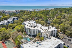 A multi-story hotel with rooftop amenities, a swimming pool, and a view of the ocean. - Ground level Villa with Community Indoor & Outdoor Pool + Free Activities! (Hilton Head Island)