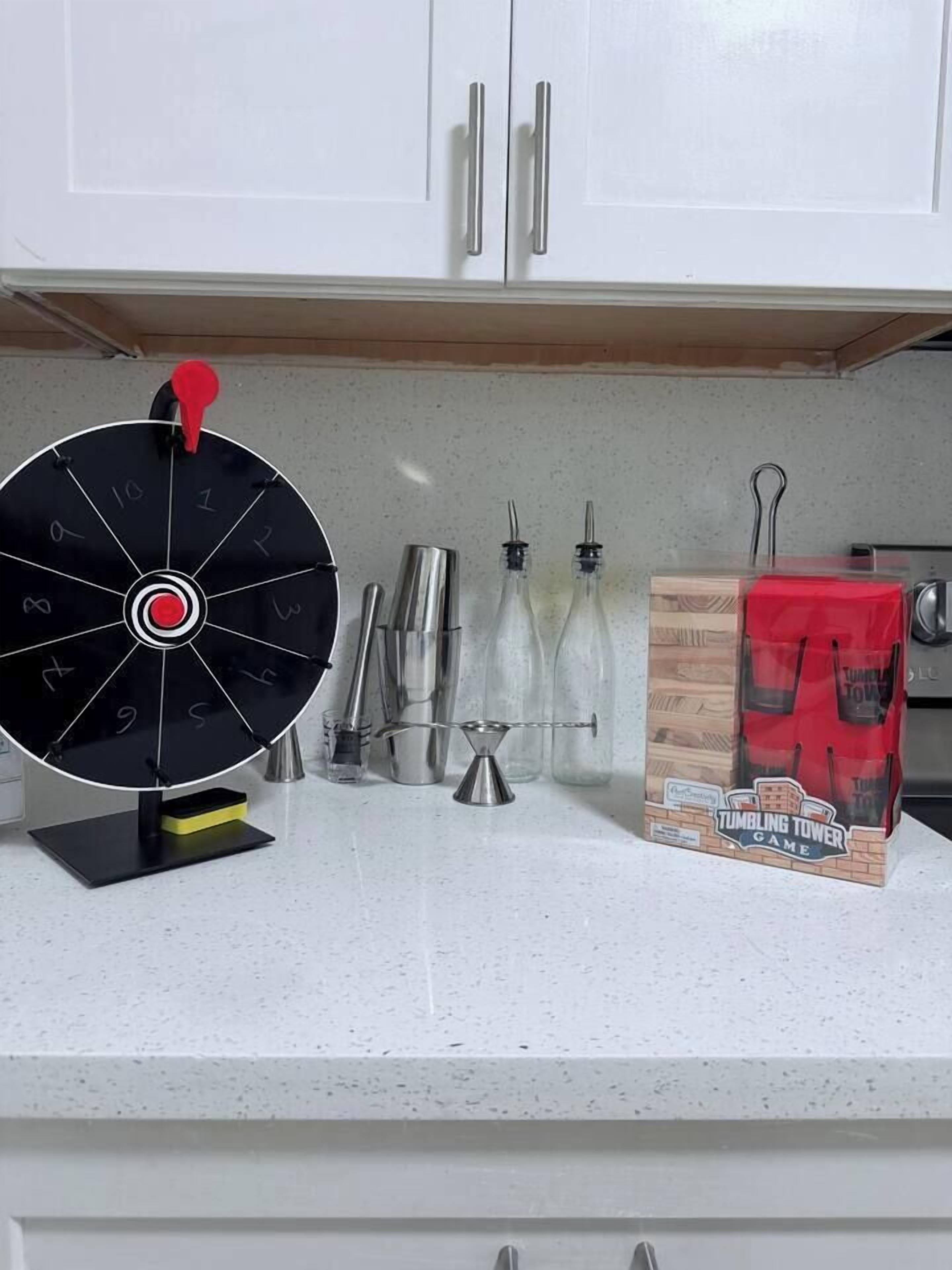 Un comptoir de cuisine avec une roue à poterie, une boîte de jeu de quilles et un ensemble de quilles.