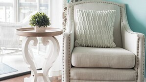 A chair with a textured cushion and a small potted plant on a round table. - Waterview #105 - condo with tranquil Intracoastal views in Indian Shores. (Indian Shores)