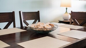 A dining table with a glass bowl of seashells, wooden chairs, and a lamp in the background. - Waterview #105 - condo with tranquil Intracoastal views in Indian Shores. (Indian Shores)