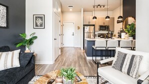 Una sala de estar moderna con sofá, mesa de centro y una cocina con comedor.