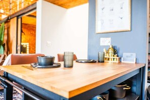 Une table en bois, sur laquelle se trouvent un bol, un récipient tressé et une assiette.