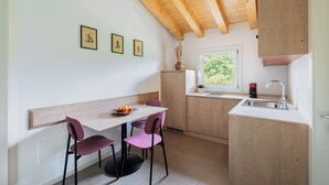 Una cucina funzionale con soffitto in legno, un tavolo da pranzo con sedie, una finestra vista inclusa e un lavello.