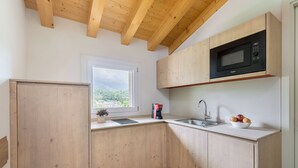 Cucina con mobili in legno, un forno a microonde, un lavello e una finestra vista.