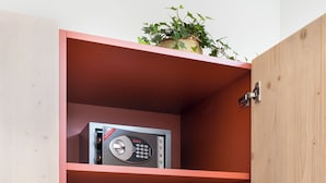 Un mobiletto in legno con una radio integrata e una piccola pianta sopra.