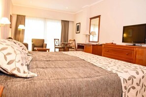 A hotel room with a large bed, a desk, a chair, a television, and a window with curtains. - Howard Johnson by Wyndham Rio Ceballos (Río Ceballos)