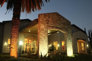 A modern building with a stone facade, large windows, and a well-lit entrance. - Howard Johnson by Wyndham Rio Ceballos (Río Ceballos)