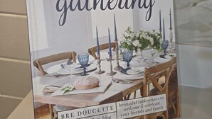 A book titled 'The Gift of Gathering' by Brie Doucette, featuring a table setting with candles and flowers. - Tiny Blanco Retreat Birdhouse (Wimberley)