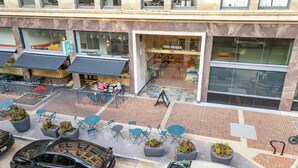 Un edifici amb un restaurant anomenat 'The Frank' i terrassa exterior amb taules i caires.