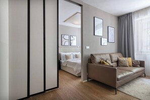 Ein modernes Hotelzimmer mit einer Couch, einem Bett und Kunstwerken an den Wänden.