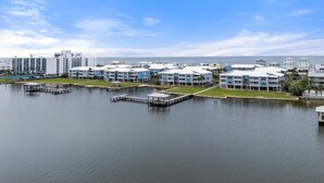 Un puerto deportivo con barcos amarrados, una masa de agua y una hilera de edificios azules con balcones.
