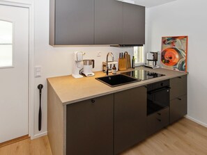 Una cocina moderna con lavavajillas incorporado, cafetera y fregadero.