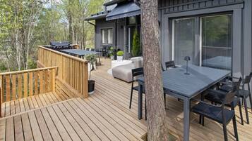 Una terraza con mesa y sillas, una parrilla y un sofá.
